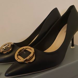 Low black heels with gold buckle detail